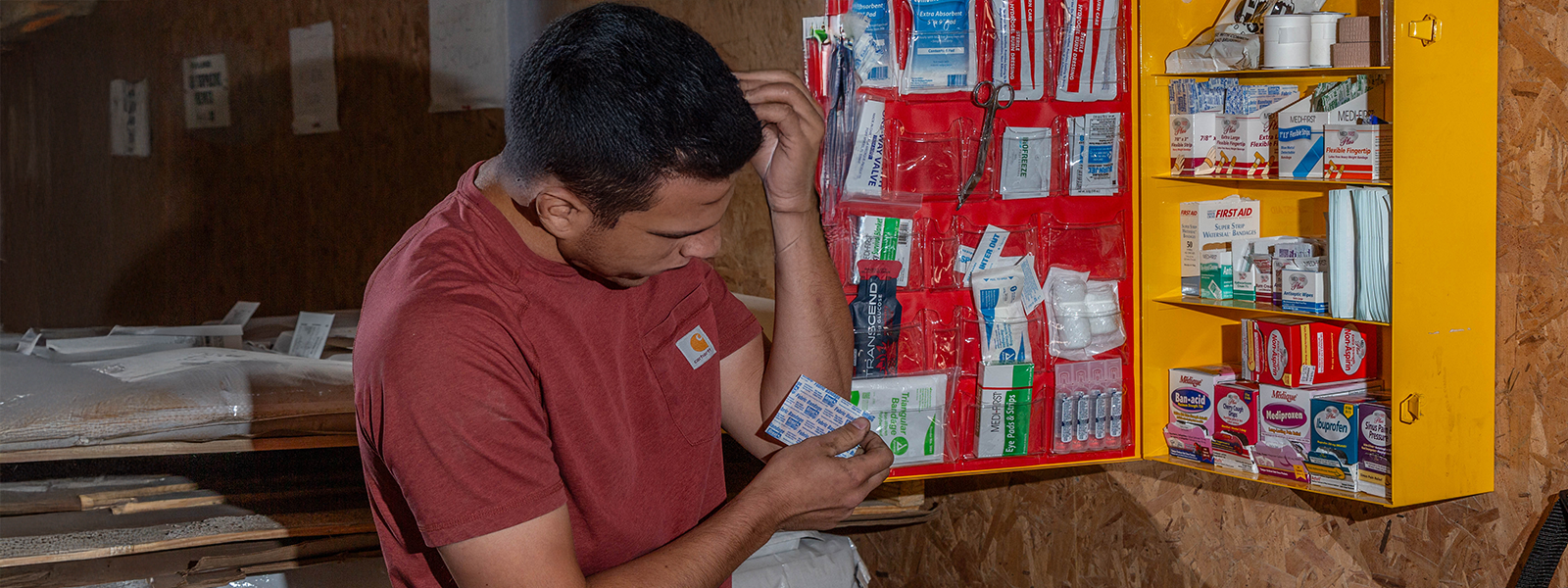A CITY First Aid Facility Services Sales and Service Manager stocking a first aid cabinet with safety / first aid products.