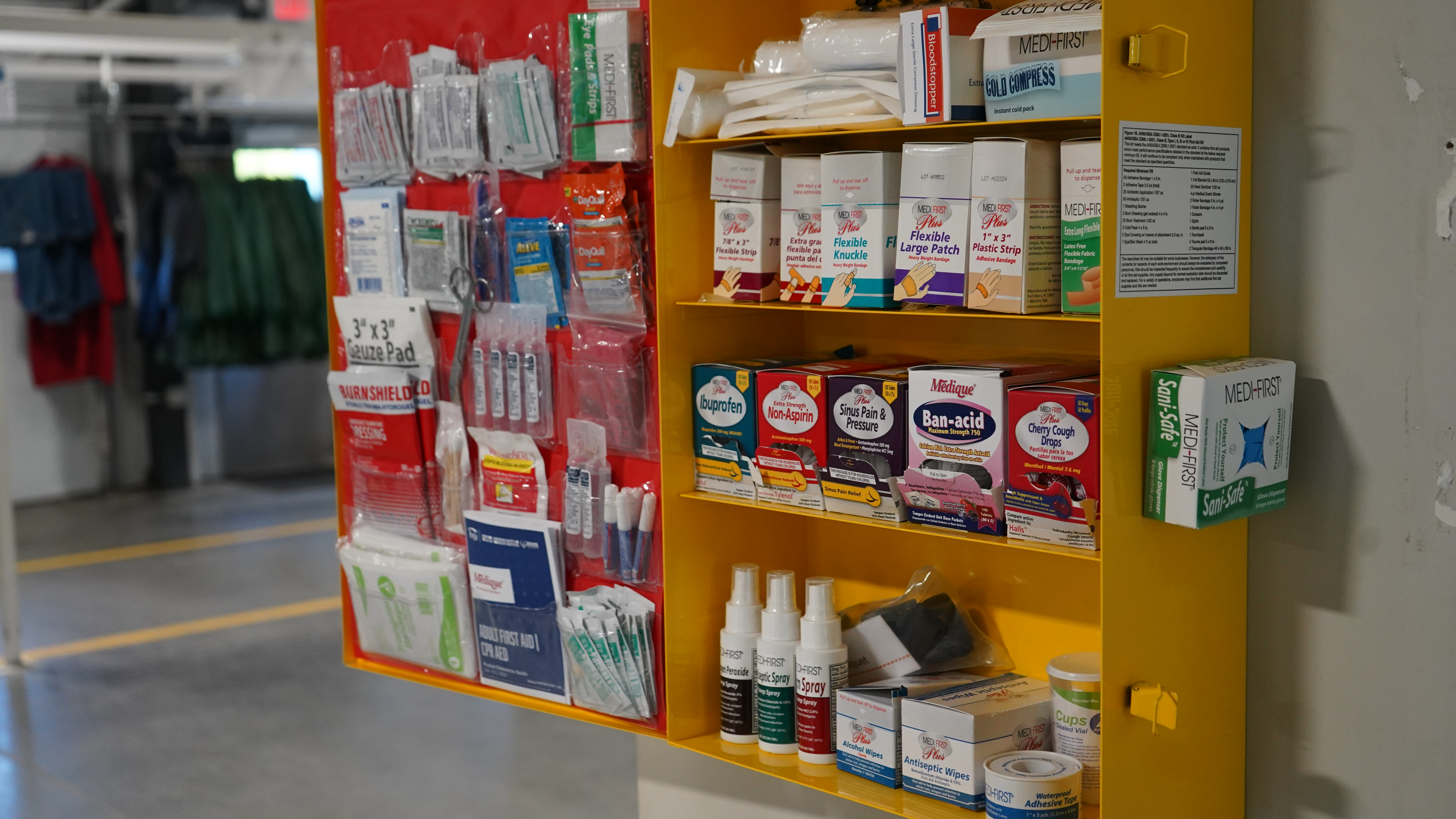 A CITY First Aid Facility Services Service Representative stocking a first aid cabinet with safety / first aid products.