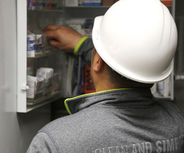 A CITY First Aid Facility Service Representative stocking a first aid cabinet with safety / first aid products.